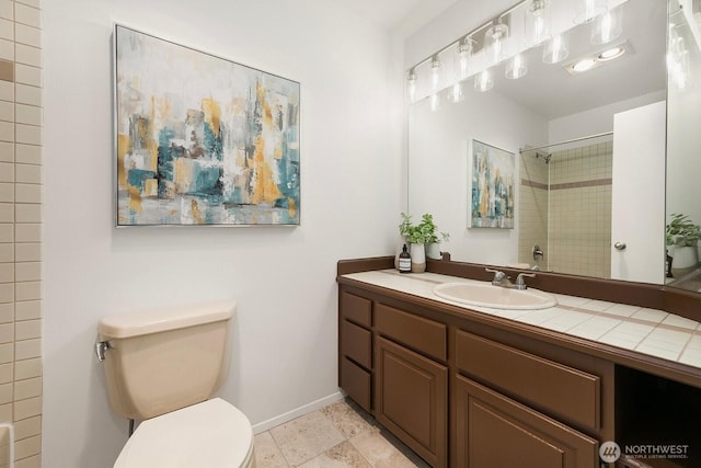 bathroom with toilet, baseboards, walk in shower, and vanity