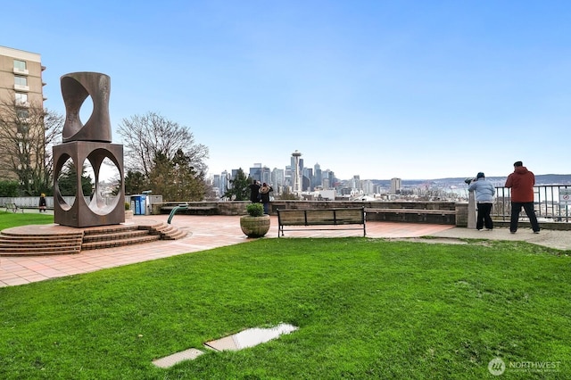 view of community featuring a view of city and a yard