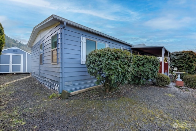 view of side of home with a storage shed