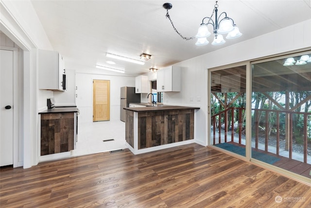 kitchen with white cabinetry, dark hardwood / wood-style floors, range, and stainless steel fridge