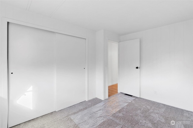 unfurnished bedroom featuring carpet flooring and a closet