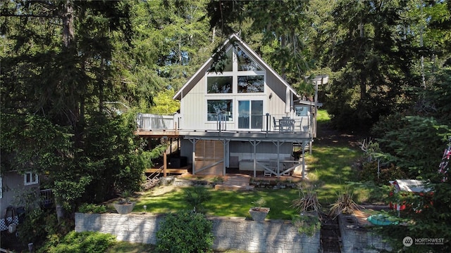 back of property featuring a deck and a lawn