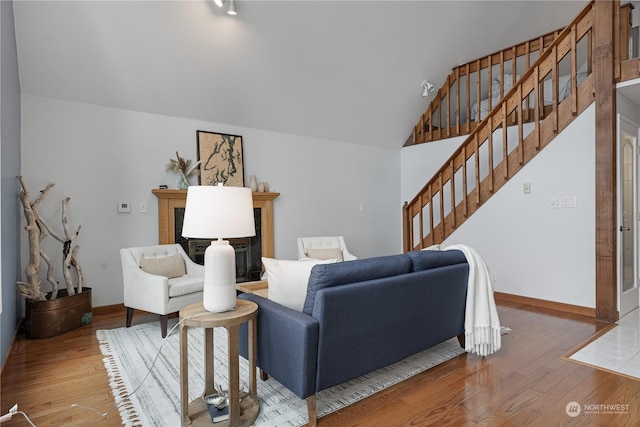 living room with wood-type flooring and high vaulted ceiling