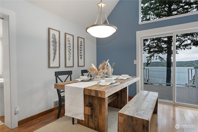 dining area featuring a water view and light wood-type flooring