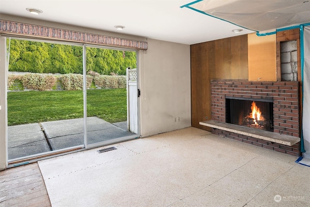 unfurnished living room featuring a brick fireplace