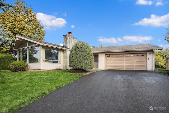 view of front of property featuring a garage and a front lawn