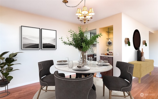 dining area with hardwood / wood-style flooring and an inviting chandelier