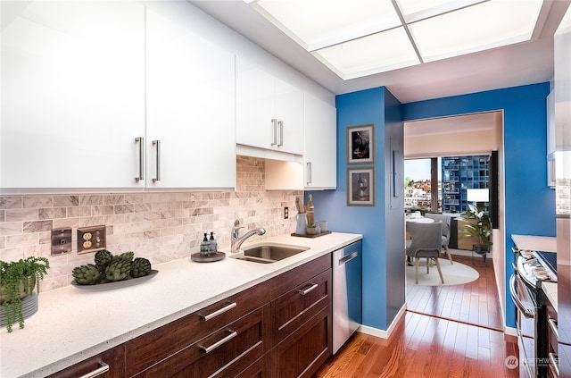 kitchen featuring appliances with stainless steel finishes, sink, white cabinets, and dark brown cabinetry