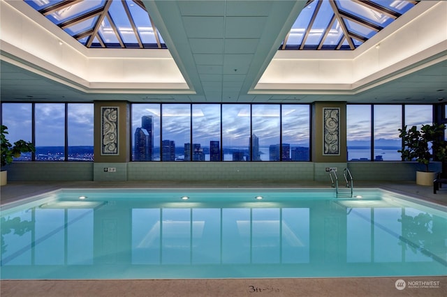 pool at dusk featuring a skylight