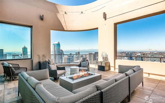 view of patio featuring a water view and an outdoor living space with a fire pit