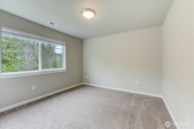 carpeted empty room featuring visible vents and baseboards