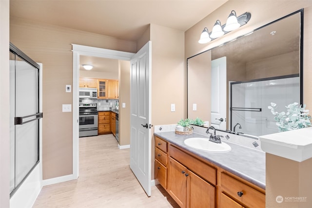 bathroom featuring hardwood / wood-style flooring, vanity, backsplash, and a shower with shower door