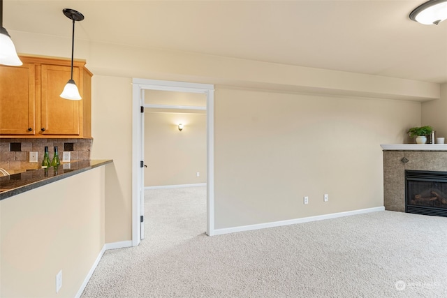 unfurnished living room with light colored carpet and a tile fireplace