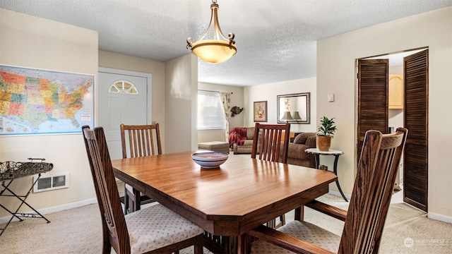 carpeted dining area featuring a textured ceiling