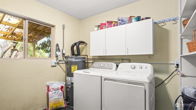 washroom featuring cabinets, secured water heater, and washer and clothes dryer