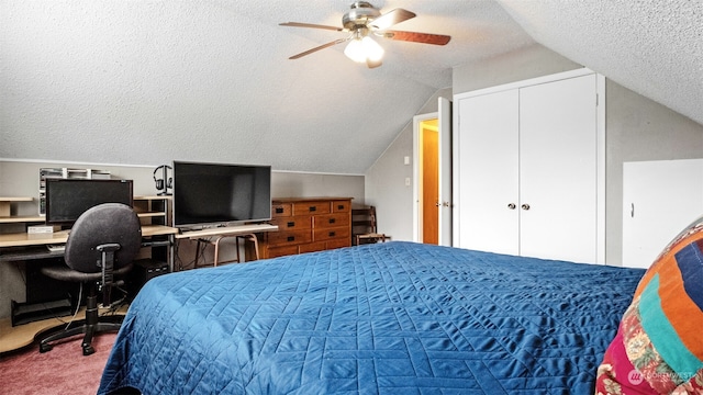 carpeted bedroom with ceiling fan, a closet, vaulted ceiling, and a textured ceiling