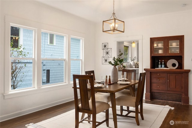 dining area featuring a notable chandelier and dark wood-type flooring