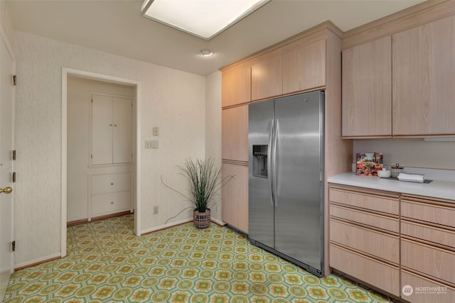 kitchen featuring stainless steel fridge and light brown cabinetry