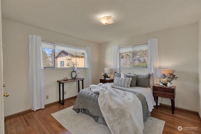 bedroom with multiple windows and light hardwood / wood-style floors