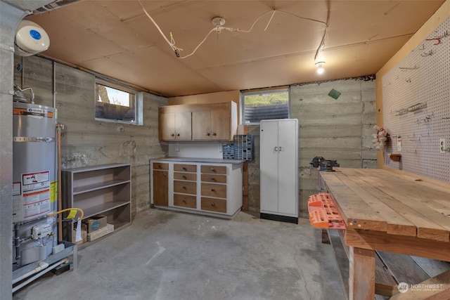 basement with water heater and a workshop area