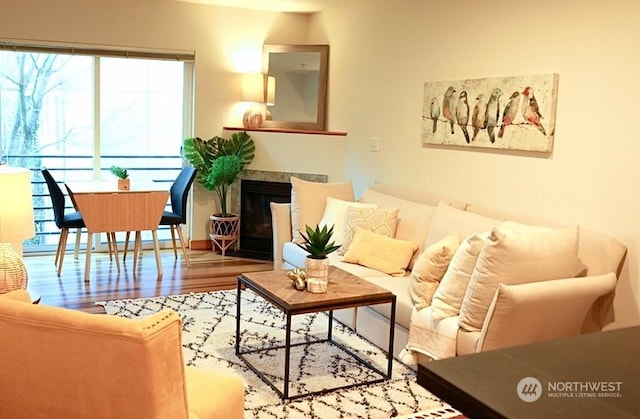 living room featuring hardwood / wood-style flooring and a tiled fireplace