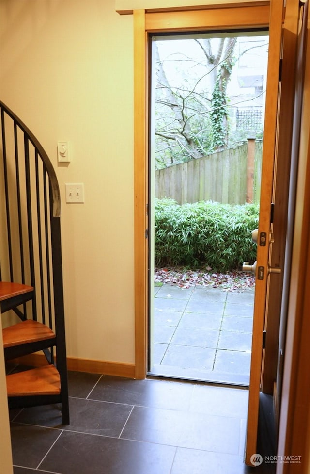 doorway with dark tile patterned floors