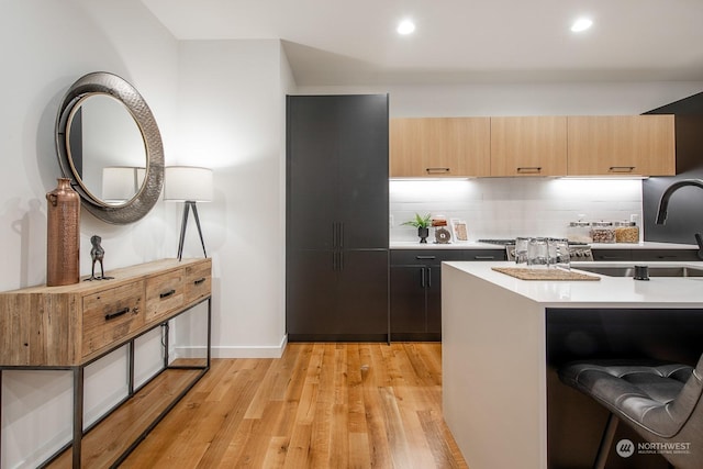 kitchen with light hardwood / wood-style flooring, light brown cabinetry, and decorative backsplash