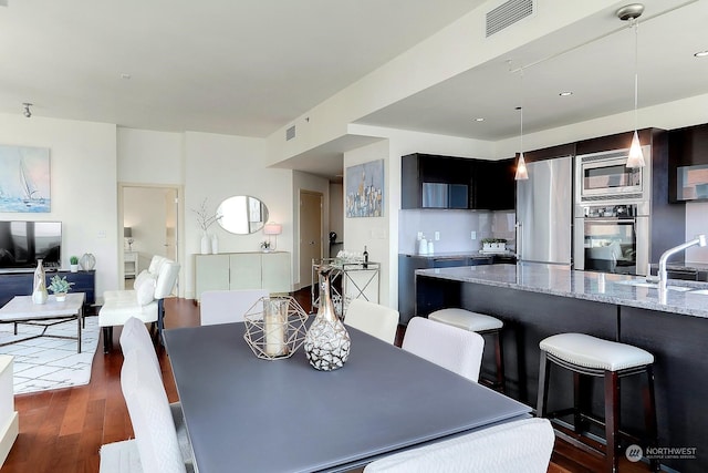 dining space featuring sink and dark hardwood / wood-style flooring