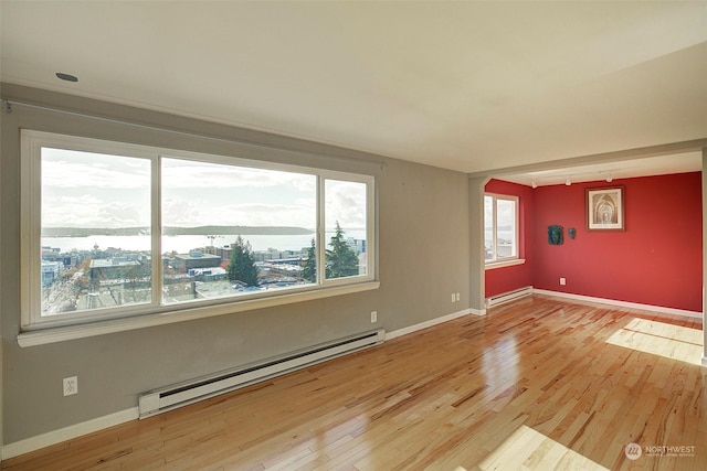 unfurnished room featuring light hardwood / wood-style flooring and baseboard heating