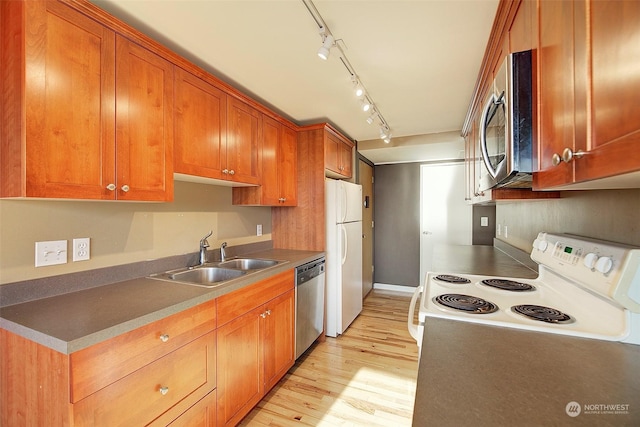 kitchen with track lighting, stainless steel appliances, sink, and light hardwood / wood-style flooring