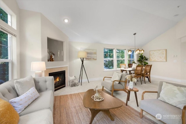 carpeted living room featuring plenty of natural light, high vaulted ceiling, and a notable chandelier