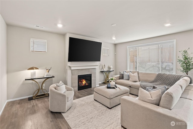 living room featuring hardwood / wood-style floors and a tile fireplace