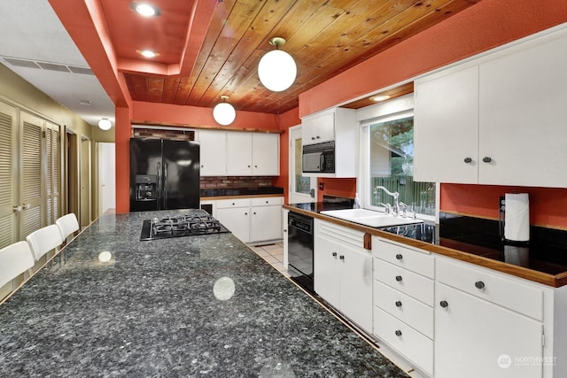 kitchen with sink, white cabinets, decorative backsplash, wood ceiling, and black appliances