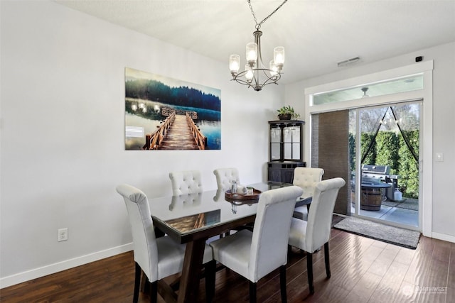 dining room featuring an inviting chandelier and dark hardwood / wood-style floors