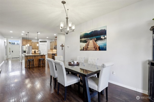 dining space with an inviting chandelier, dark hardwood / wood-style flooring, and sink