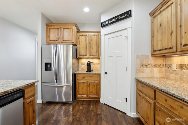 kitchen with light stone counters, stainless steel appliances, dark hardwood / wood-style floors, and decorative backsplash