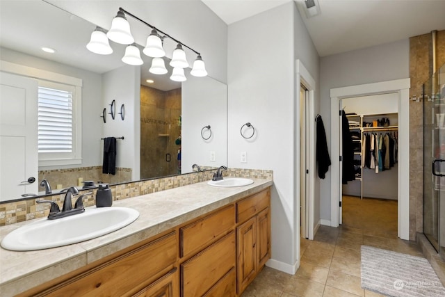 bathroom featuring tasteful backsplash, vanity, tile patterned floors, and walk in shower