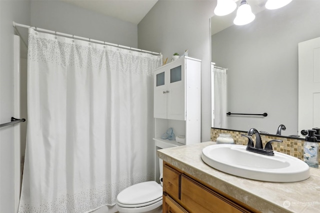 bathroom with vanity, toilet, and decorative backsplash