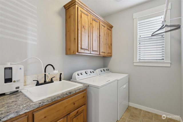 washroom featuring cabinets, sink, and washer and clothes dryer