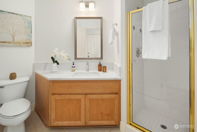 bathroom with a shower with door, vanity, tile patterned flooring, and toilet