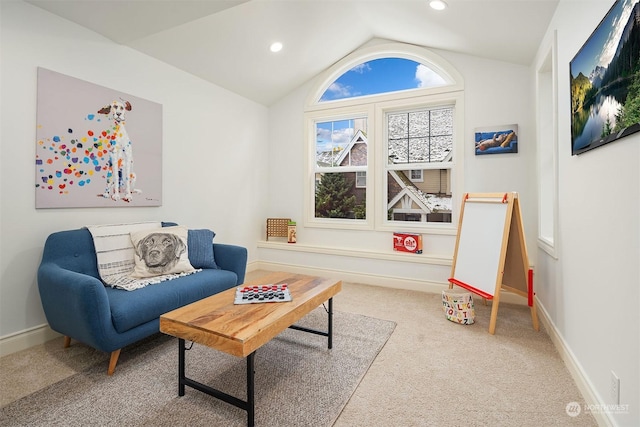 living area featuring vaulted ceiling and carpet