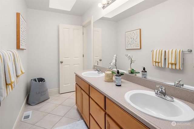 bathroom featuring vanity, a skylight, and tile patterned floors