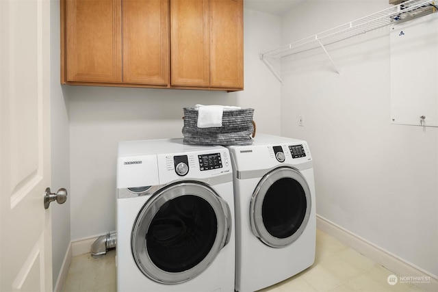 clothes washing area with independent washer and dryer and cabinets