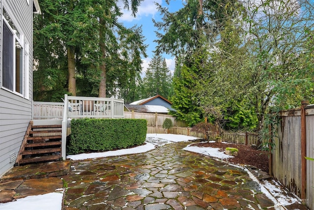 snow covered patio featuring a deck