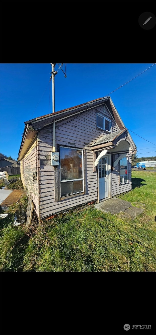 rear view of property featuring a yard