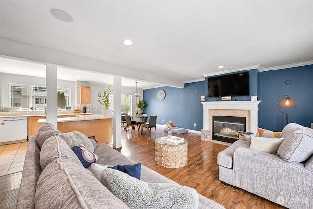 living room with ornamental molding, a fireplace, and hardwood / wood-style floors