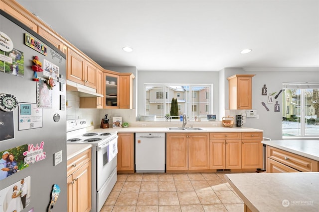 kitchen featuring light brown cabinetry, sink, white appliances, and decorative backsplash