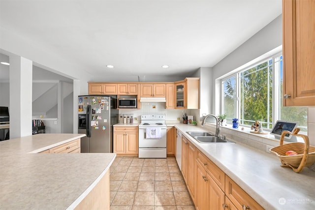 kitchen with tasteful backsplash, appliances with stainless steel finishes, sink, and light brown cabinets