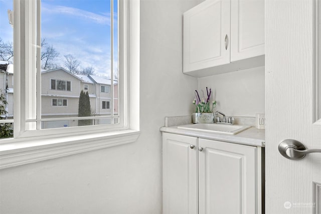 bar featuring sink and white cabinets