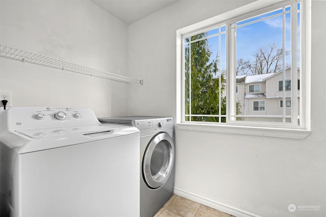 washroom with washing machine and clothes dryer and light tile patterned flooring